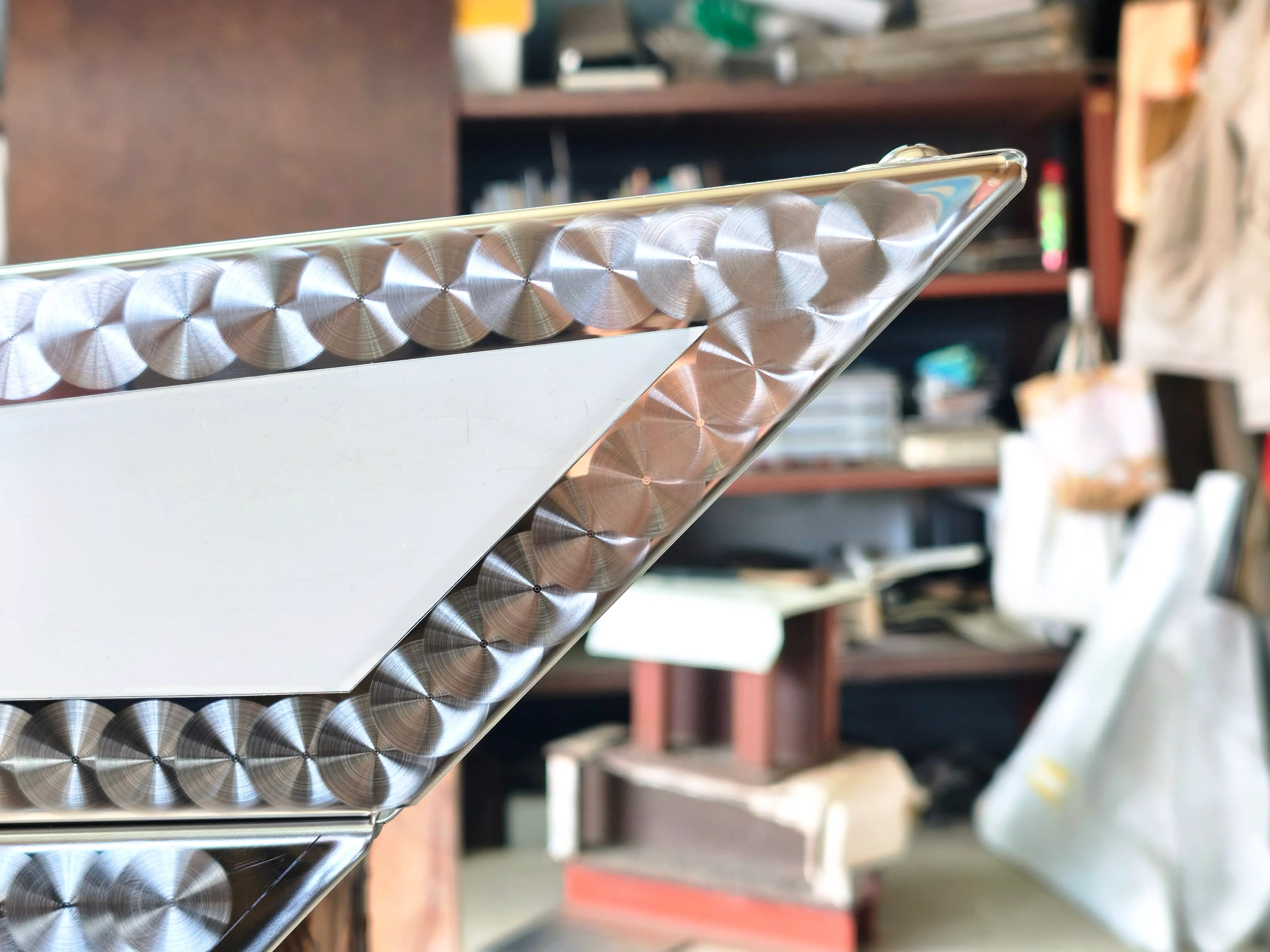 フロントバイザー先端の鋭角仕上げ — ウロコ模様ステンレスが鋭く収束するコーナー