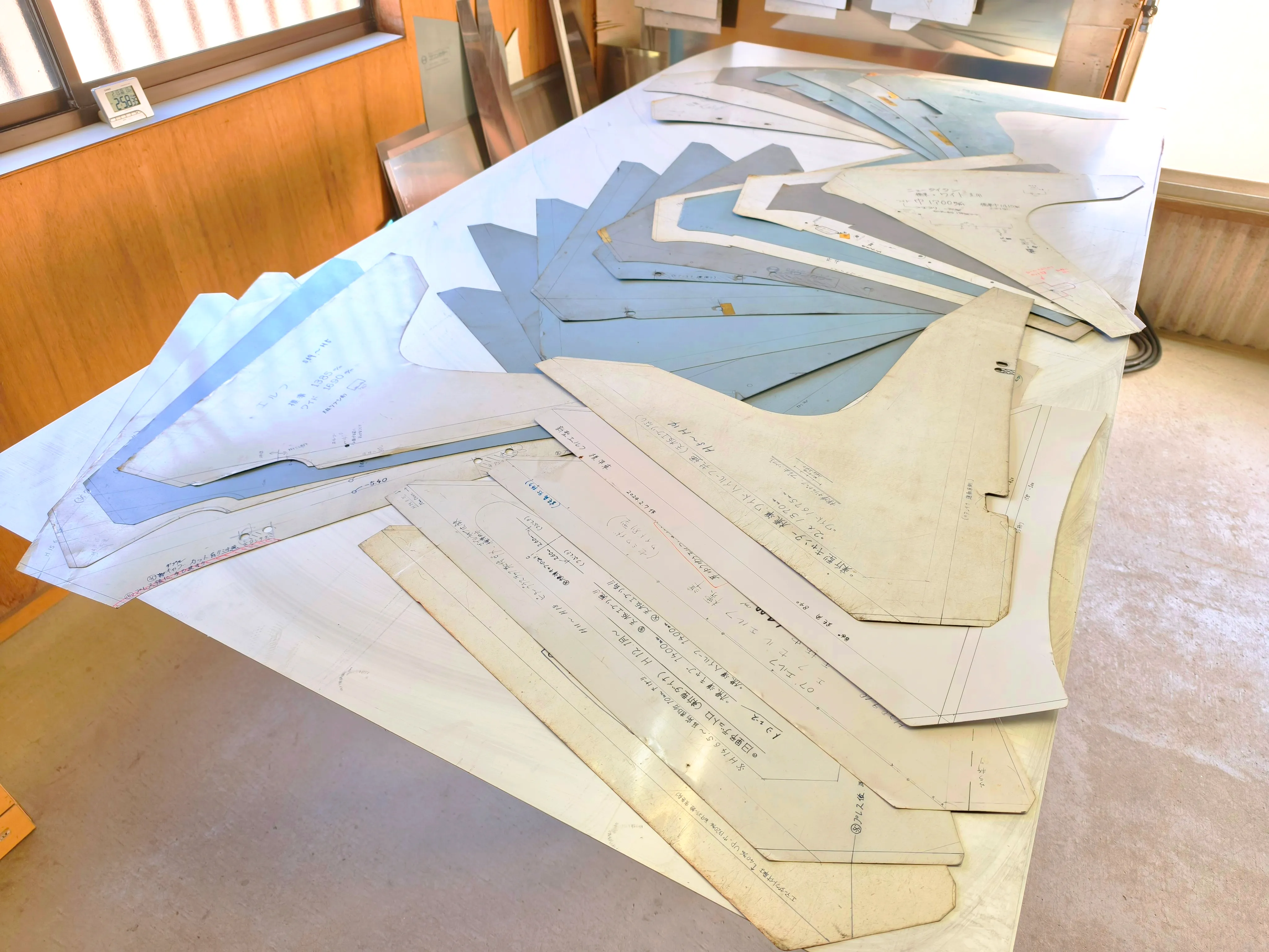 作業台に広げられたフロントバイザーの型紙。昭和から平成初期の旧車種用の型を大切に保管しています。